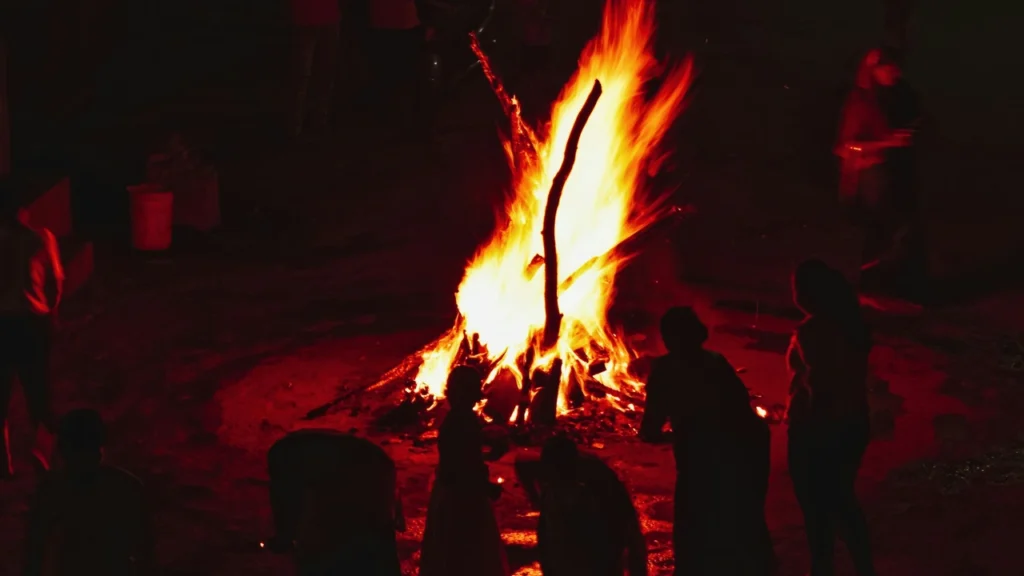 People gathered around a large bonfire at night during Baisakhi Festival celebrations, symbolizing renewal, community, and the spiritual significance of the festival in Sikhism.